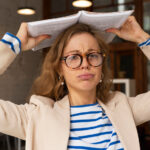 Een vrouw met bril heeft een boek op haar heeft