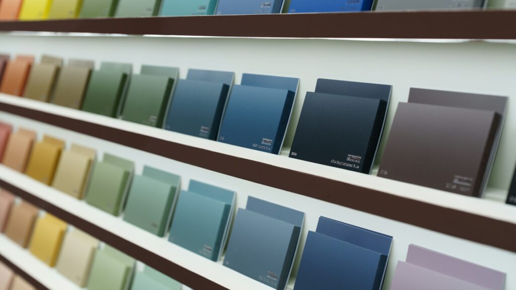 Kleurenstalen in warme en koele tinten op planken, variërend van geel tot diepblauw, als inspiratie voor interieurkleuren en creativiteit.