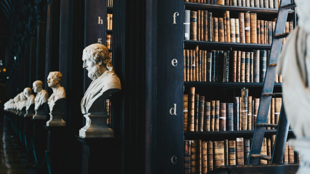 Rij bustes en oude wetboeken in bibliotheek als achtergrond bij inzendingen beoordelen
