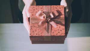 Een persoon overhandigt een feestelijk ingepakt cadeau, perfect gekozen voor het juiste moment.
