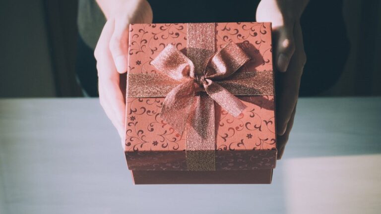 Een persoon overhandigt een feestelijk ingepakt cadeau, perfect gekozen voor het juiste moment.