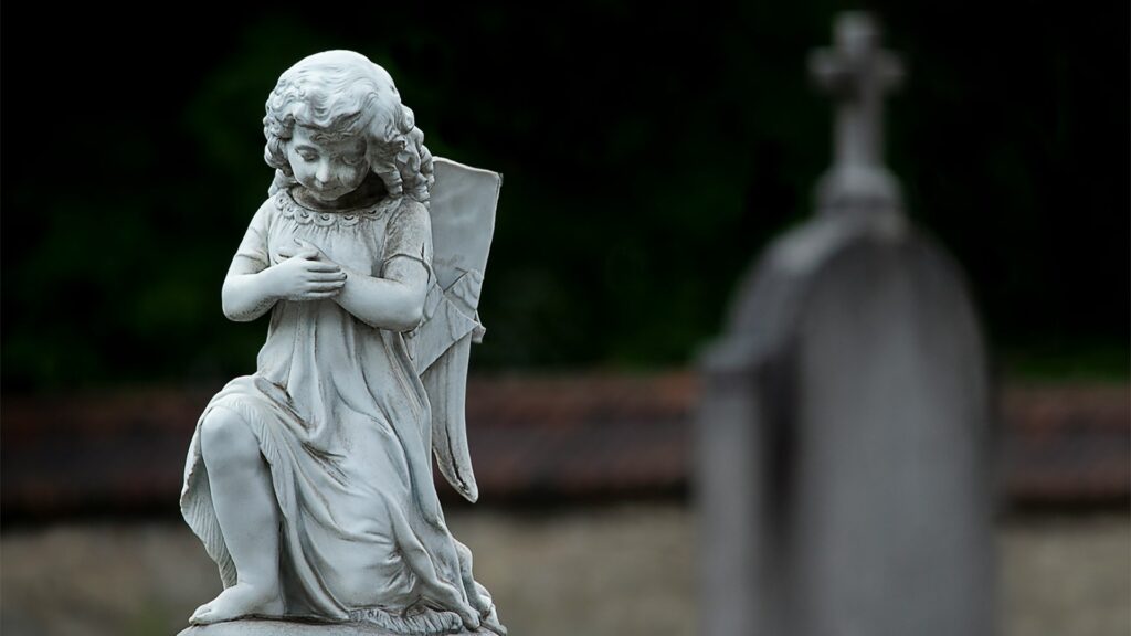 Wit engelbeeld op een grafsteen symboliseert rust en steun voor nabestaanden tijdens het rouwproces.