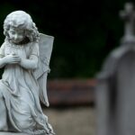 Wit engelbeeld op een grafsteen symboliseert rust en steun voor nabestaanden tijdens het rouwproces.