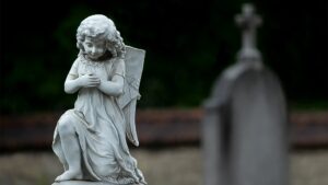 Wit engelbeeld op een grafsteen symboliseert rust en steun voor nabestaanden tijdens het rouwproces.